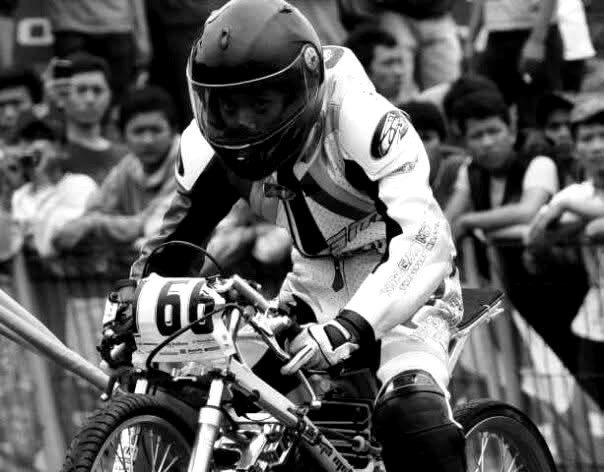 NGM racer in full gear, race bib 66, mid-race
