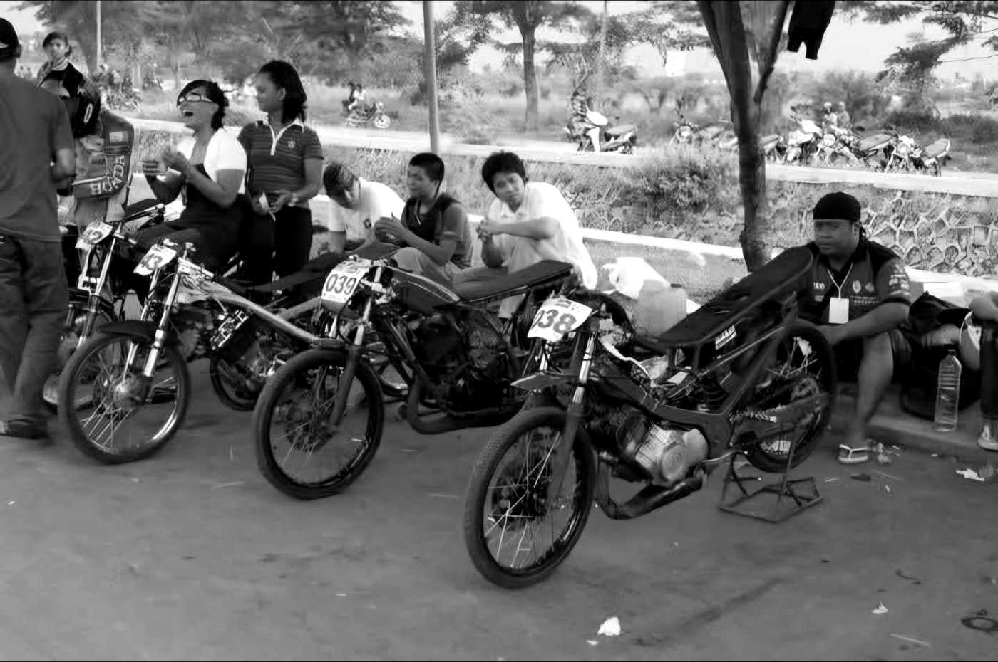 Lineup of drag racing bikes with race numbers